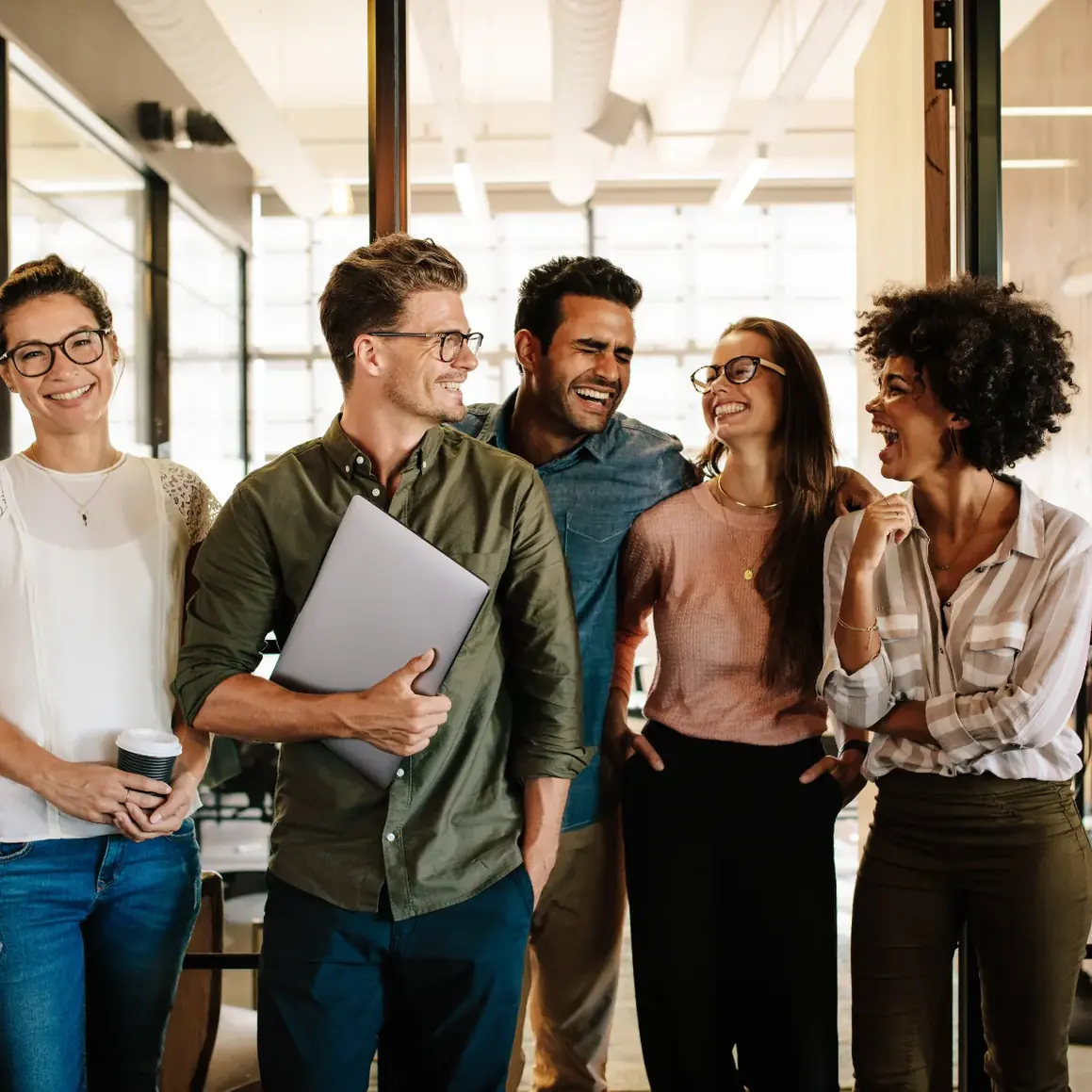 Equipe conversando em ambiente de trabalho claro e aberto
